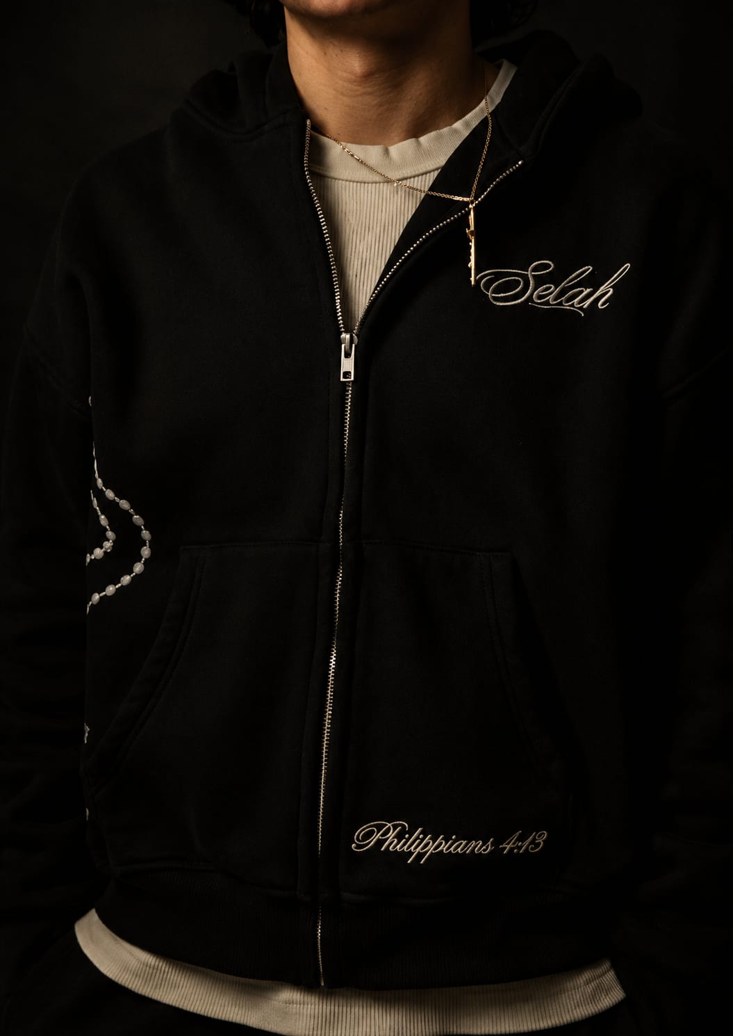 Rosary Zip Hoodie in matte black, worn with the rosary print and Philippians 4:13 embroidery visible